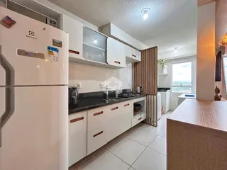 Foto de uma cozinha moderna com armários brancos e bancadas escuras.