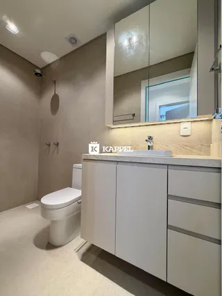 Foto de um banheiro com pias e vaso sanitário branco.