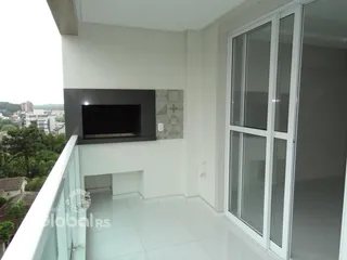 Vista da área comum de um imóvel em Lajeado com porta de vidro e parede de lareira.