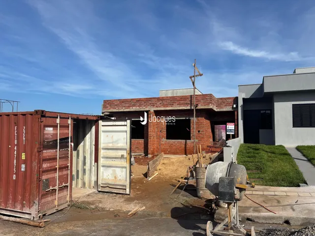 Vista externa de uma construção com contêineres ao fundo.