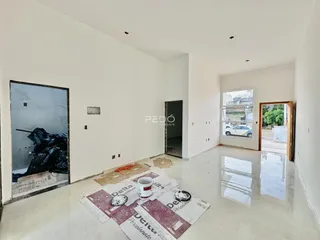Foto do interior de um ambiente com paredes brancas e piso em obra.