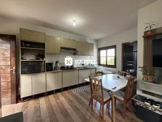 Uma cozinha moderna com armários de madeira e mesa de jantar.