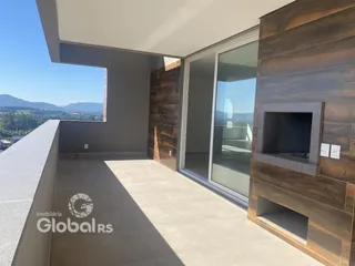 Sala de estar com grandes janelas e revestimento de madeira escura.