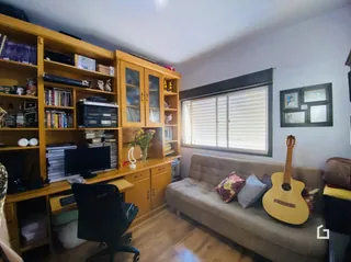 Sala de estar com estantes em madeira e sofá.