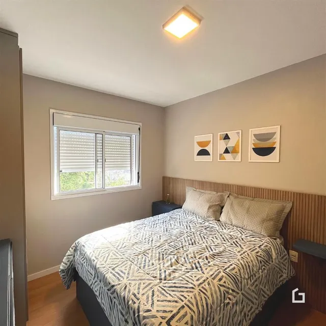 Quarto com cama e janela em um apartamento.