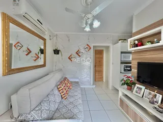 Sala de estar com sofá e espelho em um imóvel no Brasil.