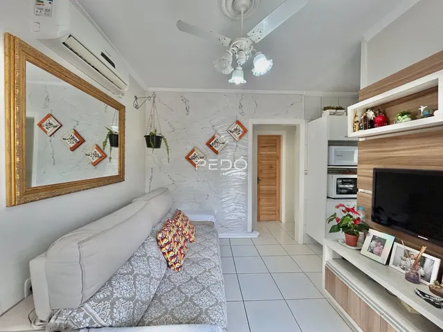 Sala de estar com sofá e espelho em um imóvel no Brasil.