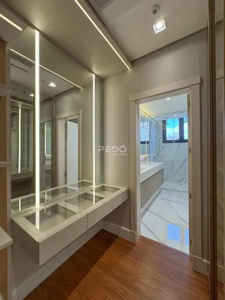 Interior de um corredor com espelhos e piso de madeira.