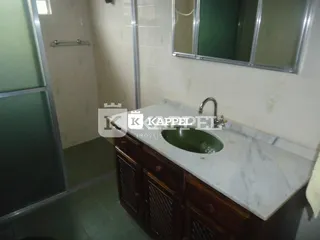 Cozinha com bancada de mármore e armários de madeira.
