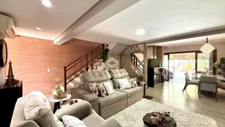 Sala de estar com parede de tijolos e sofá de cor neutra.