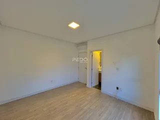 Sala de estar com piso de madeira clara e paredes brancas.