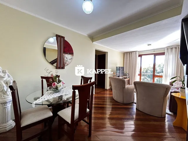 Sala de estar com piso de madeira e móveis de couro.