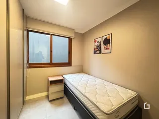 Quarto com janela e cama em ambiente interno.