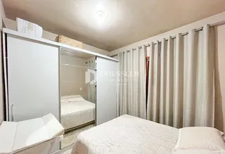 Quarto com armários e espelho refletindo outro quarto.