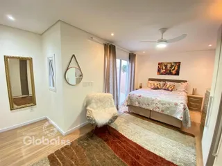 Quarto com piso de madeira e decoração de cama.