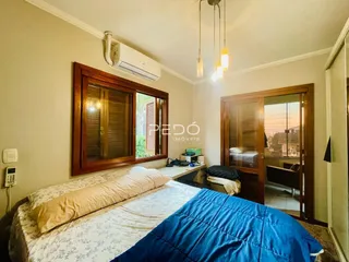 Quarto com cama e armário de madeira em um imóvel no Brasil.