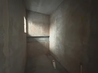 Foto de um corredor interno com paredes de concreto aparente.