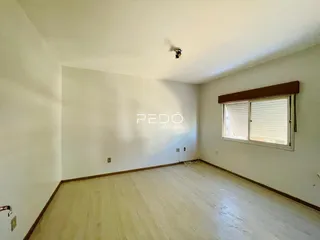 Sala de estar com piso de madeira clara e paredes brancas.