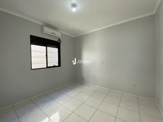 Ambiente interno de uma sala com piso de cerâmica e janela.