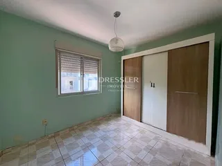 Sala de estar com piso de cerâmica e parede verde na residência.