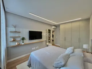 Quarto moderno com cabeceira e armário em um ambiente claro.