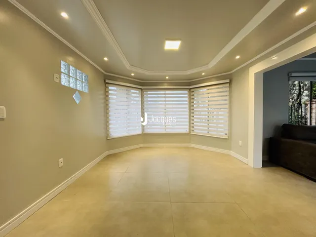 Sala de estar com paredes claras e piso liso.