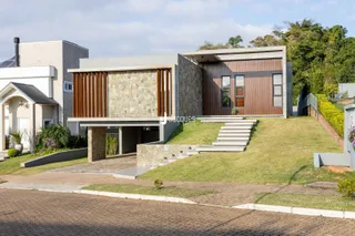 Fachada moderna de uma residência em Lajeado, Brasil, com jardim e escadaria externa.
