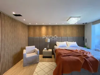 Quarto com cama e poltrona em ambiente moderno.