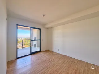 Sala de estar com porta de vidro abrindo para uma vista externa.