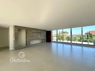 A sala possui um piso claro e uma parede de destaque em pedra.