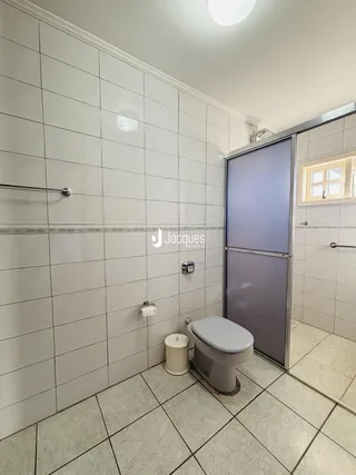 Foto de um banheiro com revestimento cerâmico claro nas paredes e piso.