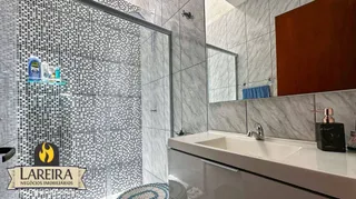 Foto de um banheiro com box de vidro e bancada branca.