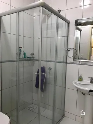 Enclosure de box de banheiro com azulejos brancos.