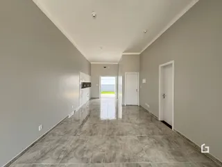 Corredor interno de uma residência com piso de cerâmica e paredes cinzas.