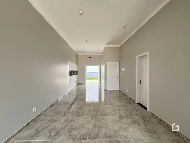 Corredor interno de uma residência com piso de cerâmica e paredes cinzas.