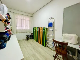 Um cômodo interno com janela e parede branca.