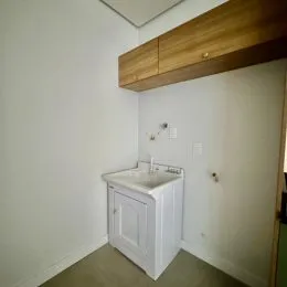 Uma bancada de banheiro branca com pia é visível na parede.