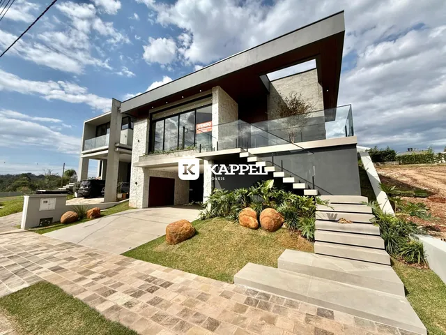 Fachada moderna de uma casa residencial com terraço e paisagismo.