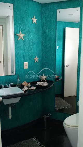Foto de um banheiro com bancada escura e parede turquesa decorada com estrelas.
