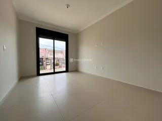 Vista interna de um cômodo com paredes brancas e piso claro, com uma grande porta de vidro voltada para o exterior.