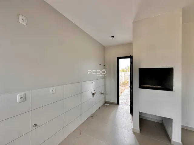 Hall de entrada com paredes brancas e portas brancas em um imóvel.