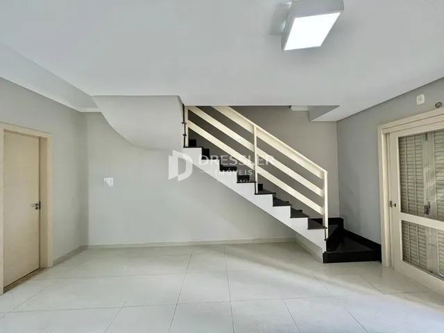 Foto de um espaço interno com escadaria e paredes brancas.