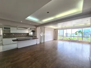 Sala de estar com piso de madeira e grande janela.