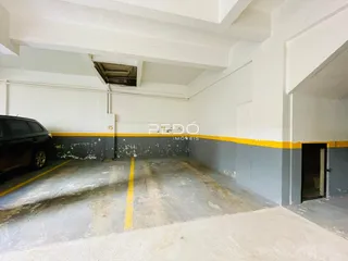 Foto de uma área de garagem com piso de concreto e paredes pintadas.