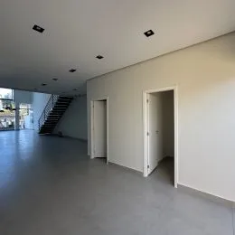 Foto de um corredor com escada visível em um imóvel.