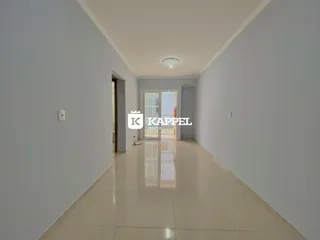 Foto de um corredor interno com paredes brancas e piso claro.