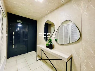Hall da casa com piso de cerâmica claro e decoração de espelho.