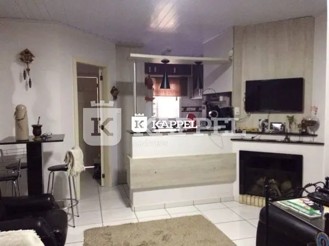 Sala de estar com lareira e televisão montada na parede.