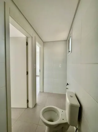 Foto de um banheiro com piso de cerâmica e vaso sanitário branco.