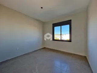 Ambiente interno de uma sala com paredes brancas e piso claro.